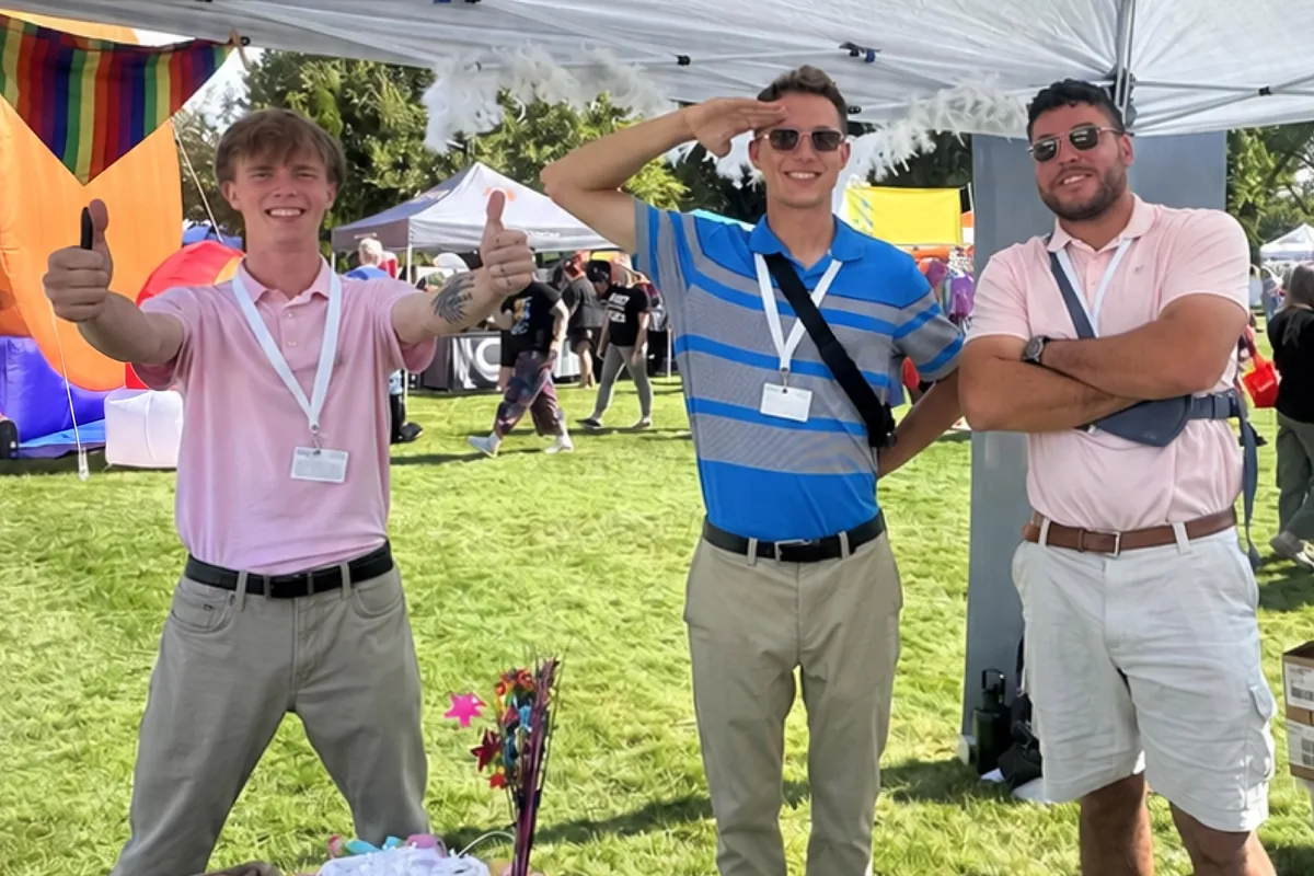 Three Iron Bloom team members under the team tent at Boise Pride
